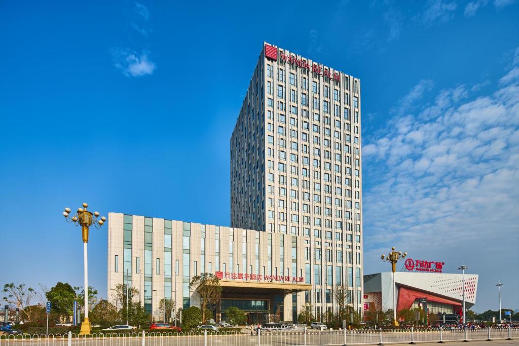 Wanda Realm Shangrao في Shangrao: مبنى أبيض طويل عليه علامة