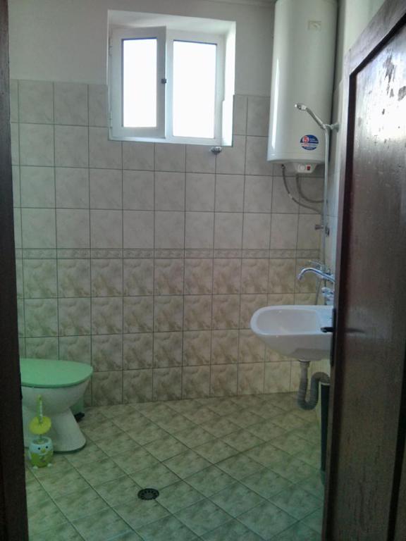 a bathroom with a sink and a toilet and a window at Proboyski Guest House in Tryavna