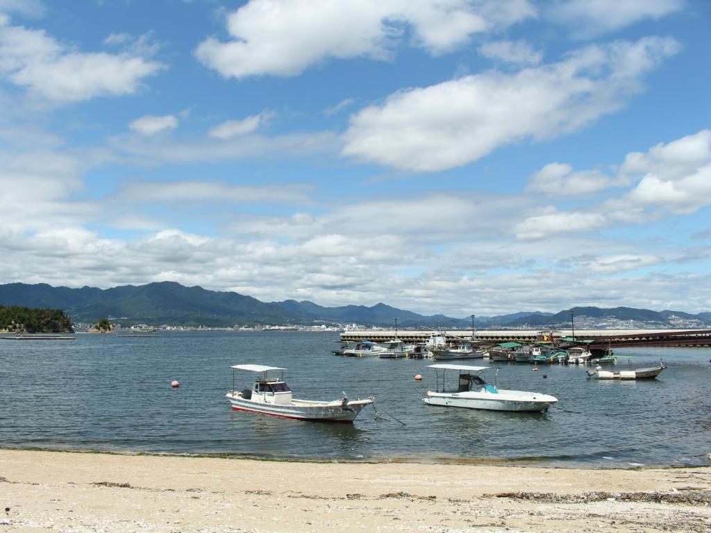 a group of boats in a body of water at Miyajima Seaside Hotel in Miyajima