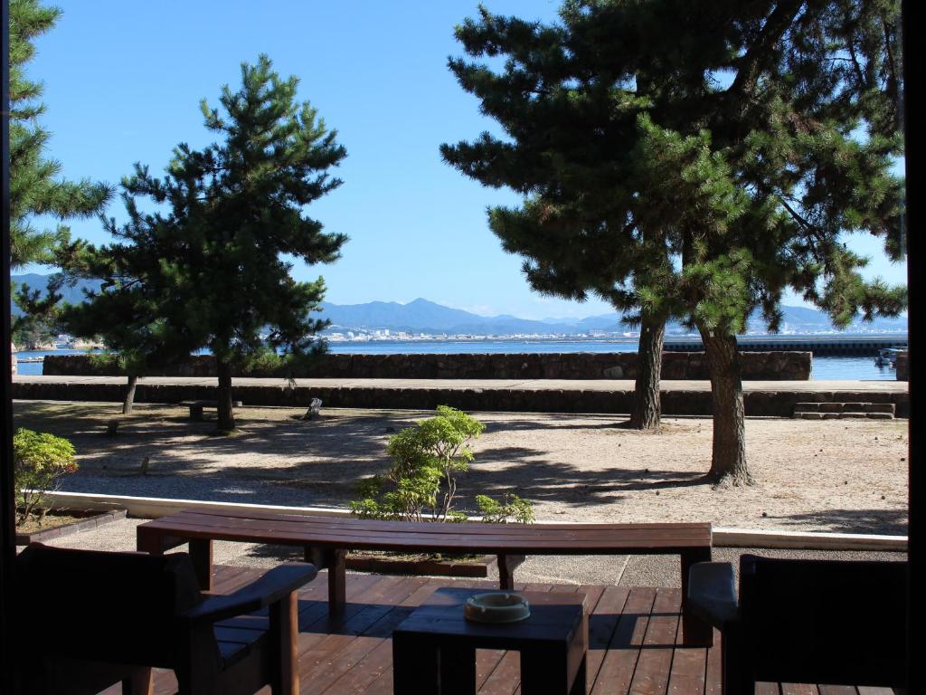 a picnic table on a patio with a view of the beach at Miyajima Seaside Hotel in Miyajima