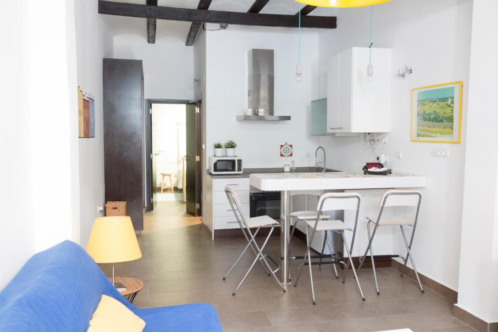 バレンシアにあるCozy fisherman's houseの白いキャビネットとスツール付きのキッチンアイランドが備わるアパートメントです。