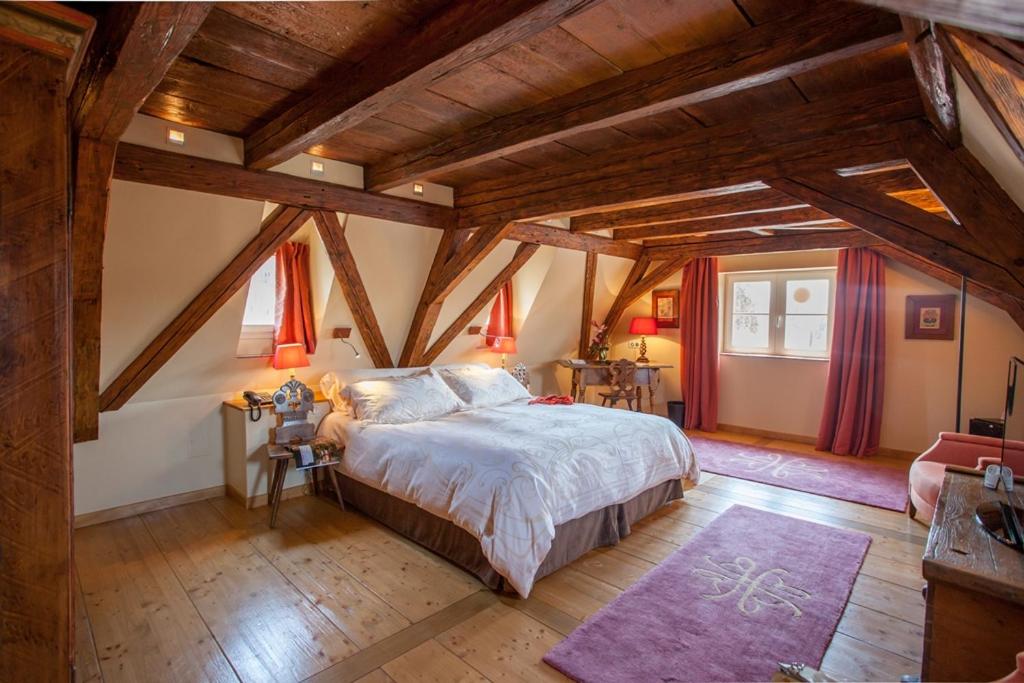 a bedroom with a large bed and wooden ceilings at Hôtel & Spa Le Bouclier D'or in Strasbourg