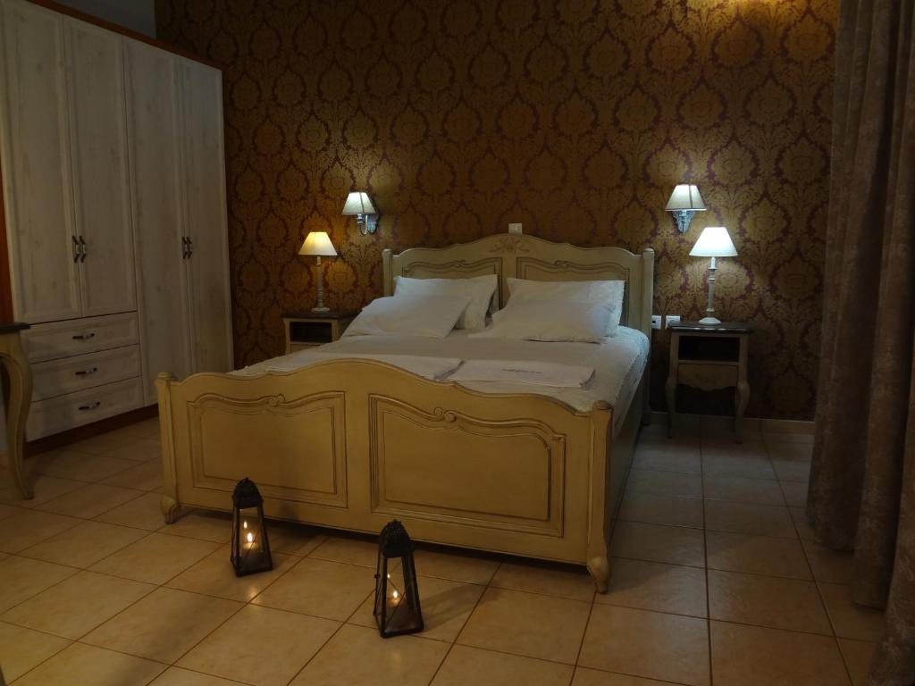 a bedroom with a large bed with two lights on the floor at Villa Anastasia in Pefki