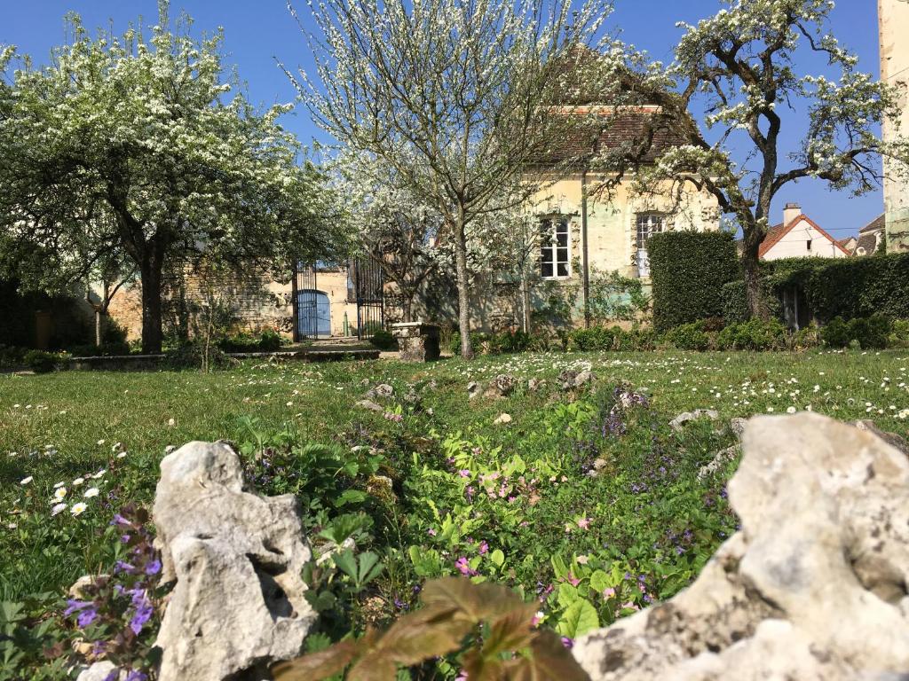 um jardim em frente a uma casa com flores em Maison d'Hôtes Chandon de Briailles em Savigny-lès-Beaune