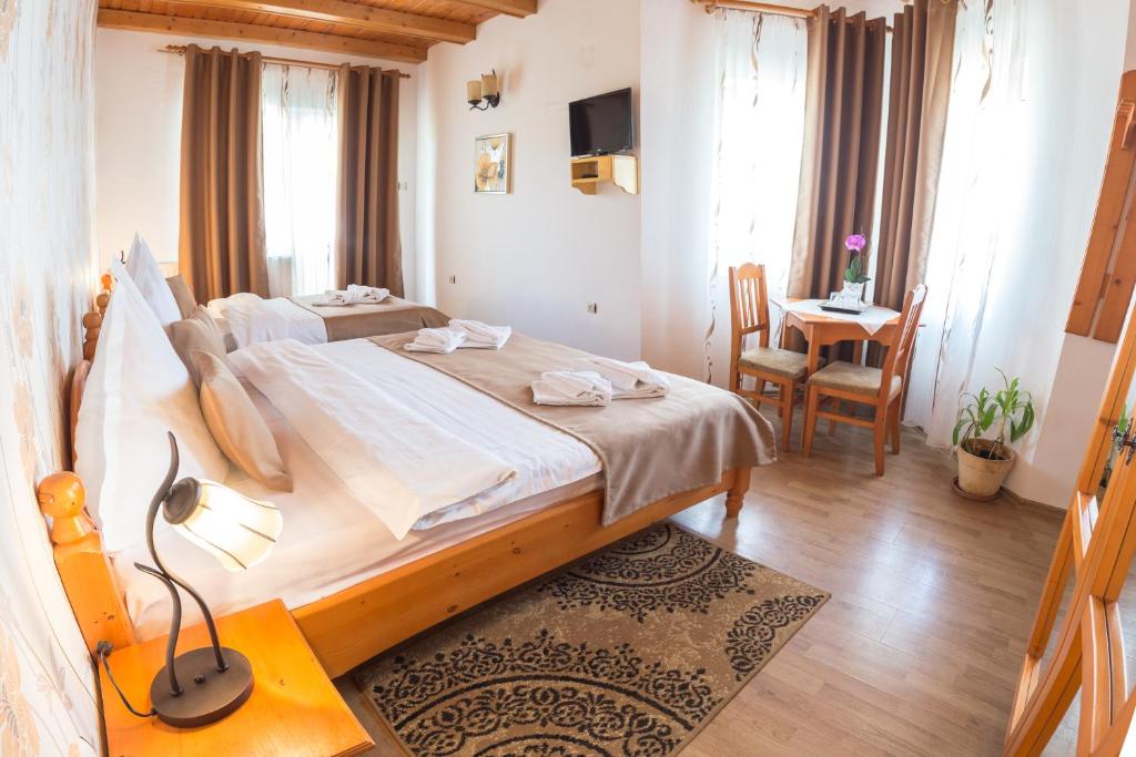 a bedroom with a large bed and a table and chairs at Pensiunea Faur in Sebeş