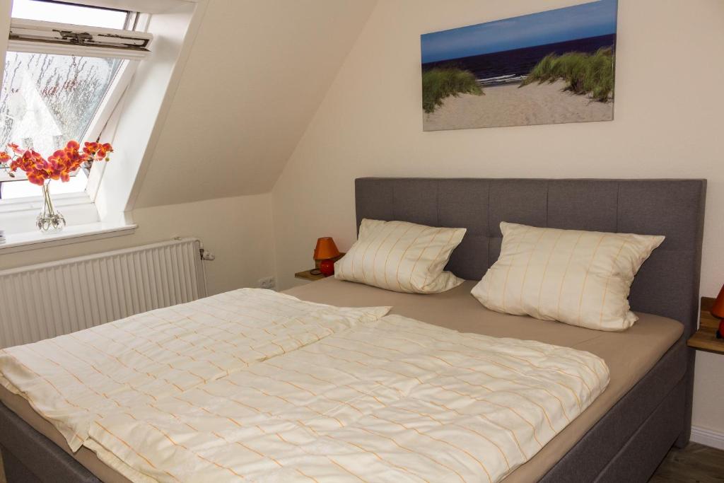a bedroom with a bed and a window at Gästehaus Margareth in Büsum