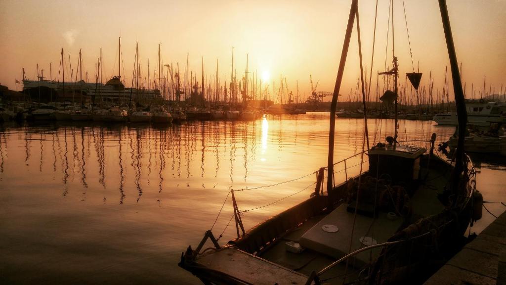 a boat is docked in a marina at sunset at Hôtel Amirauté in Toulon