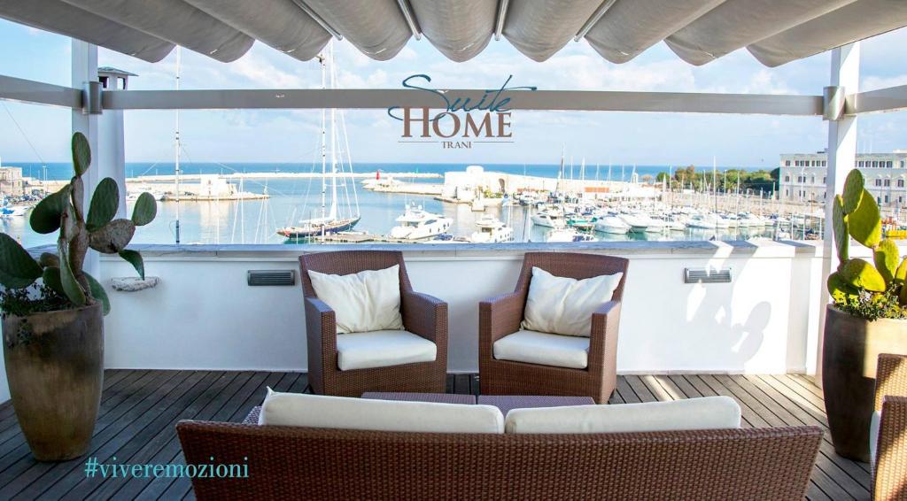 uma varanda com duas cadeiras e uma marina com barcos em B&B Suite Home Trani em Trani