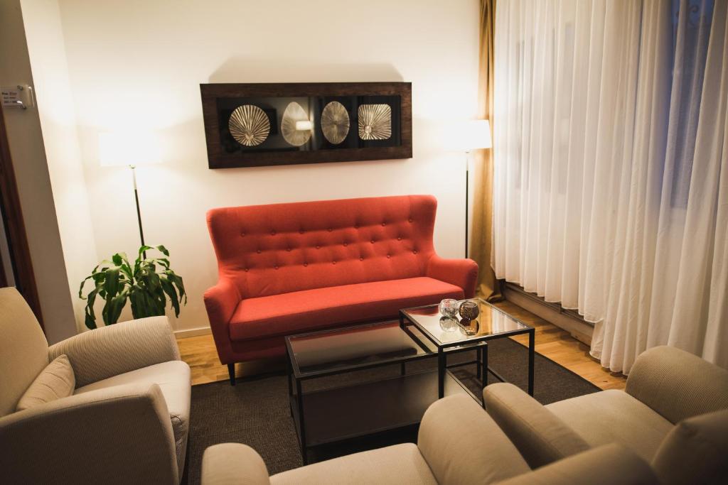 a living room with a red couch and a table at Stay Xtra Hotel Kista in Stockholm