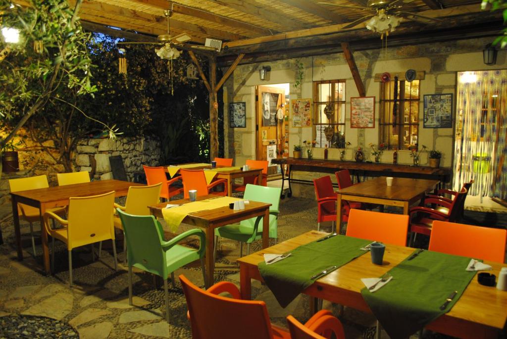 a restaurant with wooden tables and colorful chairs at Eski Datca Evleri in Datca