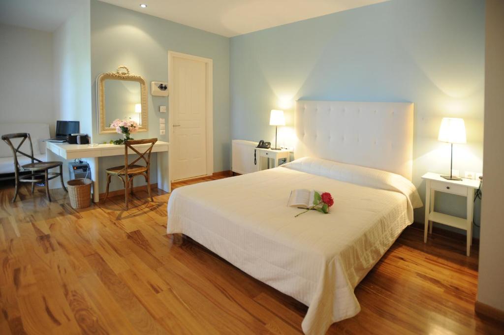 Un dormitorio con una cama blanca con una flor. en Boutique Hotel Kentrikon & Bungalows, en Agios Ioannis