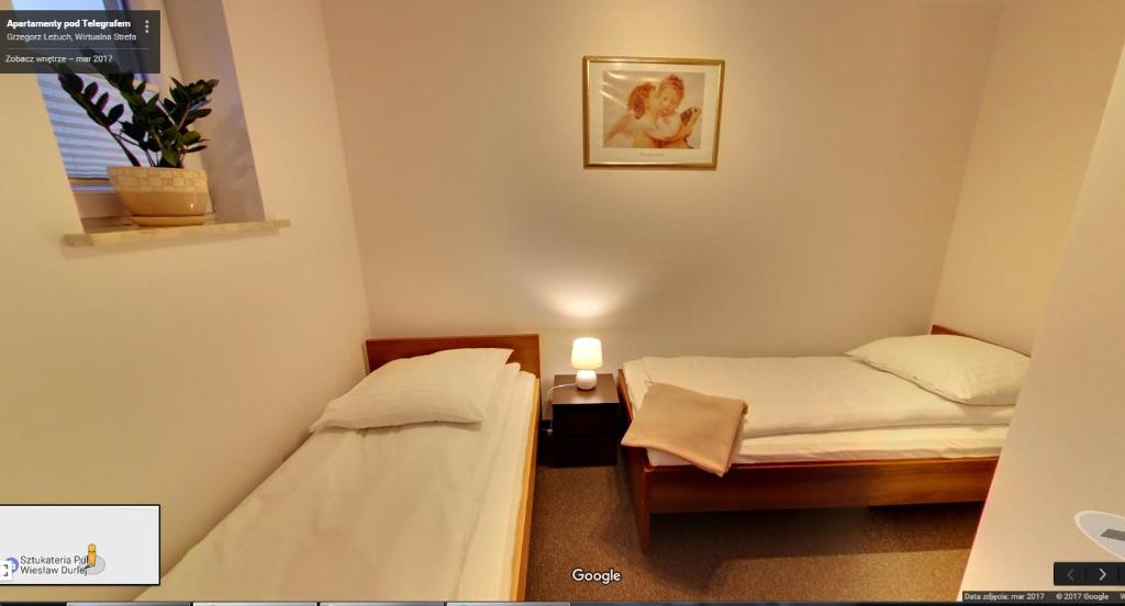 a small room with two beds and a window at Apartamenty Pod Telegrafem in Kielce