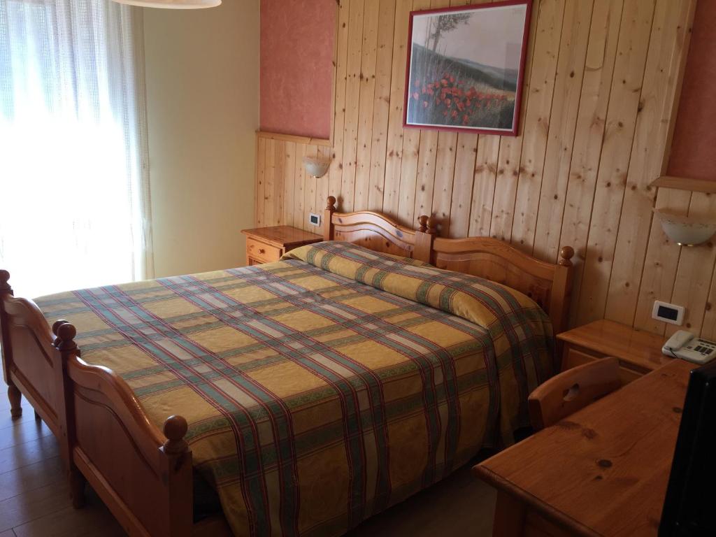 ein Schlafzimmer mit einem Bett mit einer karierten Decke in der Unterkunft Al Garibaldino in Posina