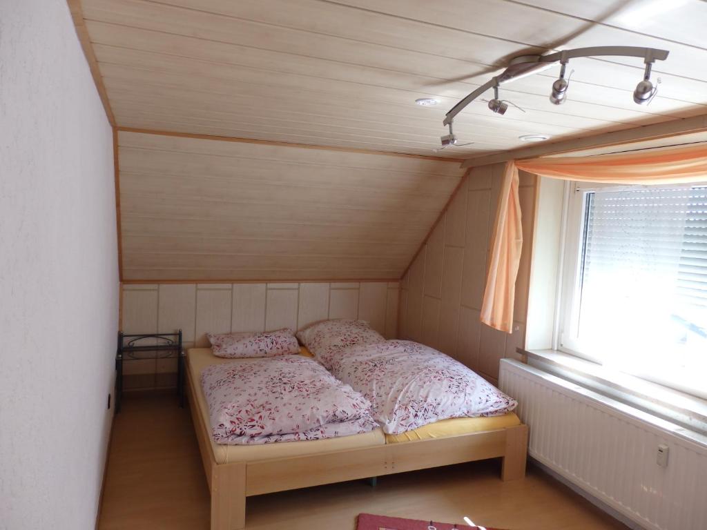 Cama pequeña en habitación con ventana en Wohnung Kronacher en Stadtsteinach