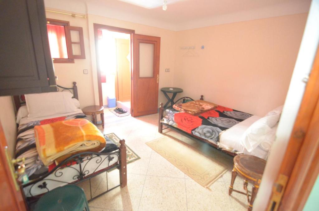 een kamer met 2 aparte bedden in een kamer bij Hotel Imilchil in Zaouia ech Cheïkh
