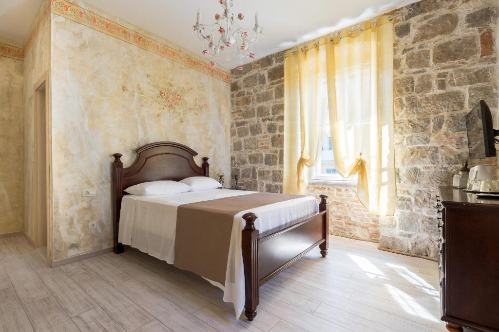a bedroom with a bed and a stone wall at Pietra Rossa in Split