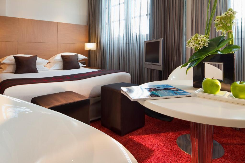 a hotel room with two beds and a table at Villathena in Paris