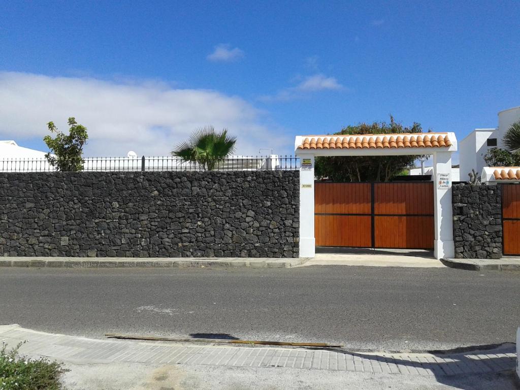 a building with a gate and a stone wall at Vivienda vacacional Finca Ribera De Cortes in Nazaret
