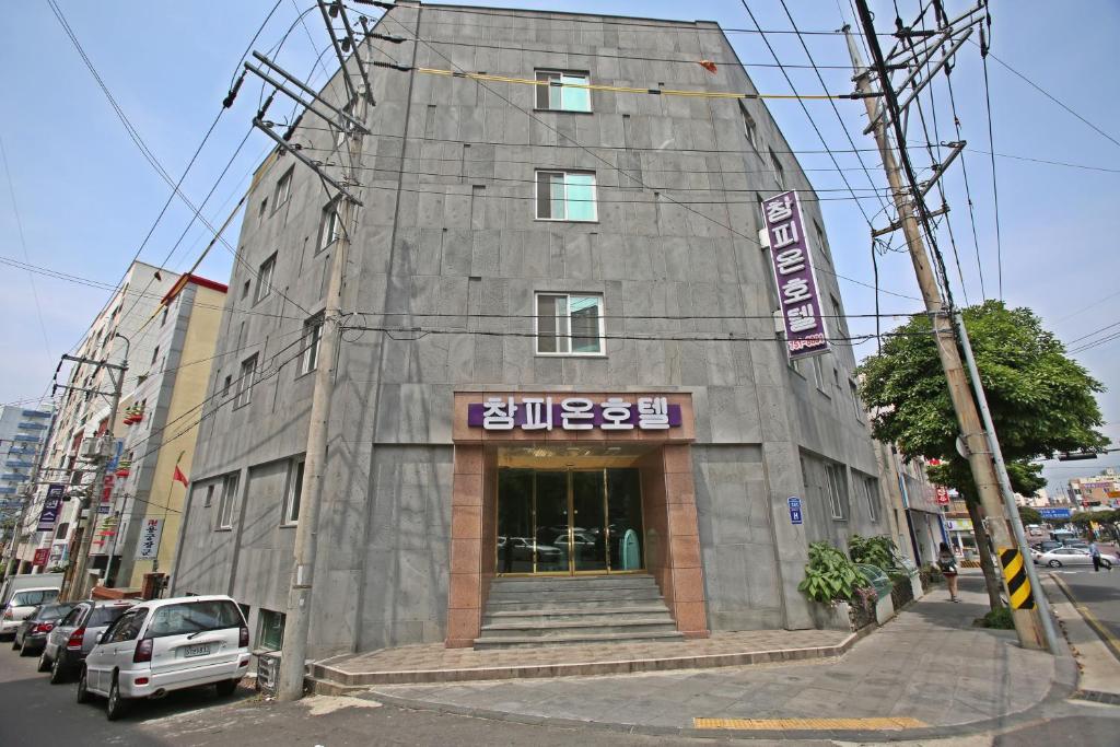 un edificio gris con un cartel en el costado en Champion Hotel, en Jeju
