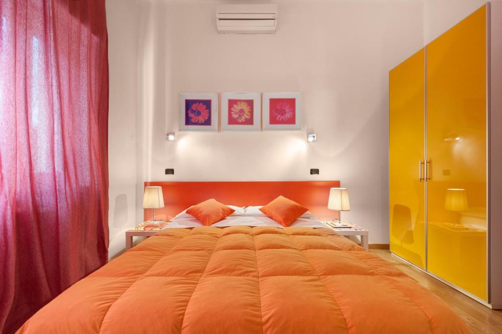 a bedroom with a large orange bed with two lamps at Lucca in Villa San Marco in Lucca