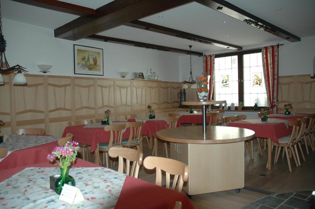 a restaurant with tables and chairs with red table cloth at Gasthof Grüner Baum in Dettelbach