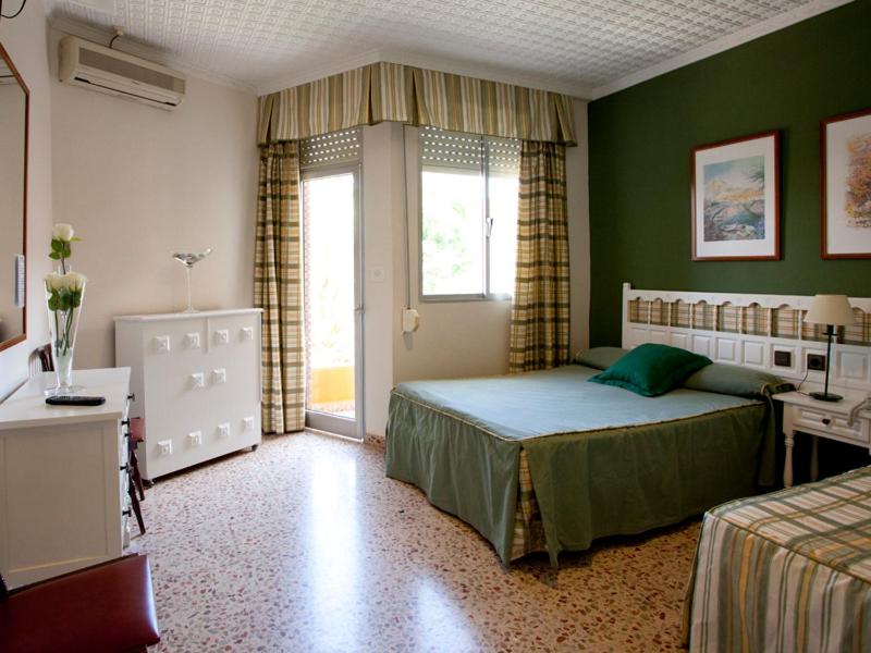 a bedroom with a bed and a desk and a window at Hotel Costa in Mazarrón