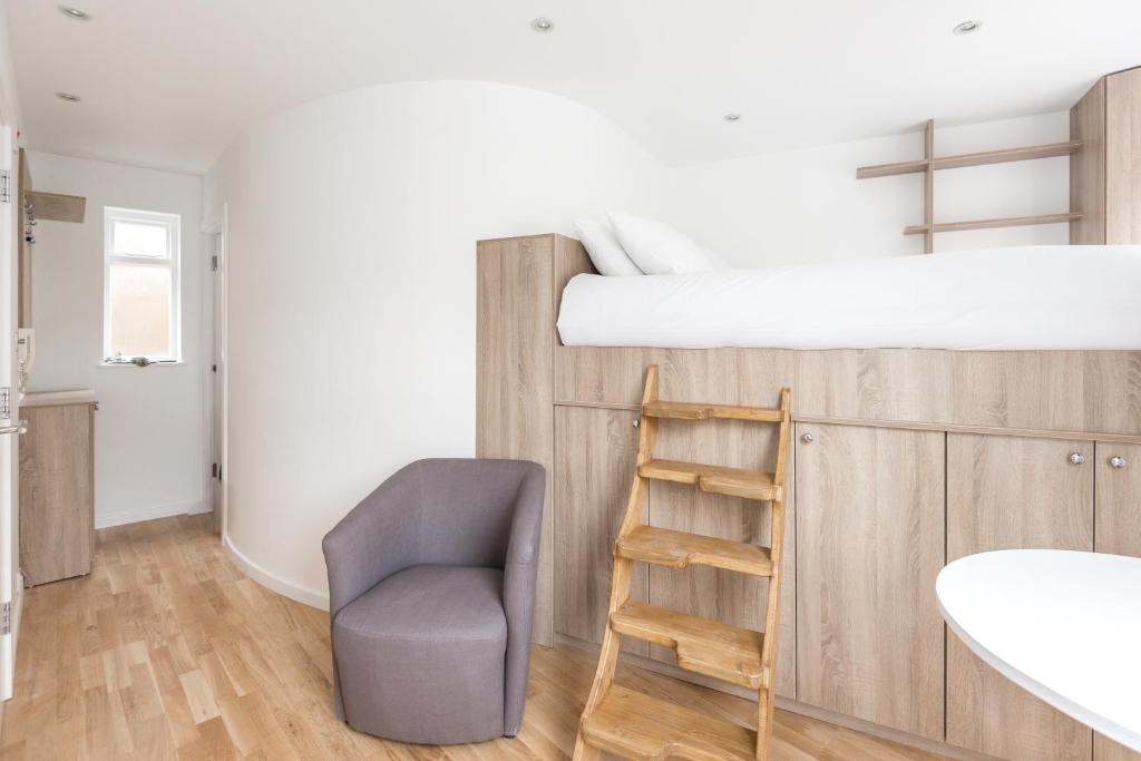 a bedroom with a bunk bed and a chair at Apartment near Harrods in London