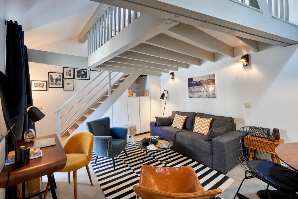 - un salon avec un canapé et un escalier dans l'établissement My Maison In Paris - Sentier, à Paris