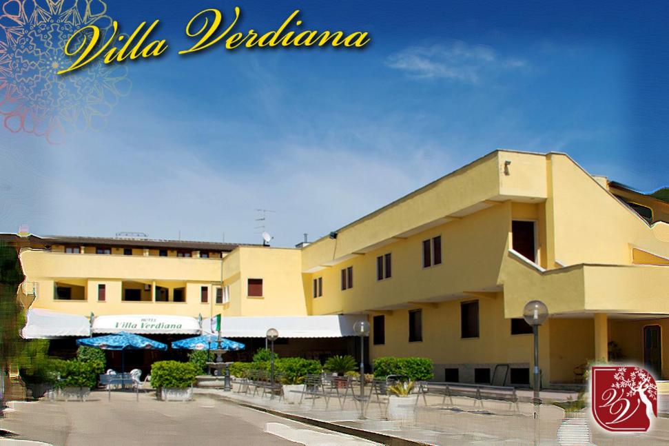 a building with tables and umbrellas in front of it at Villa Verdiana in Nettuno