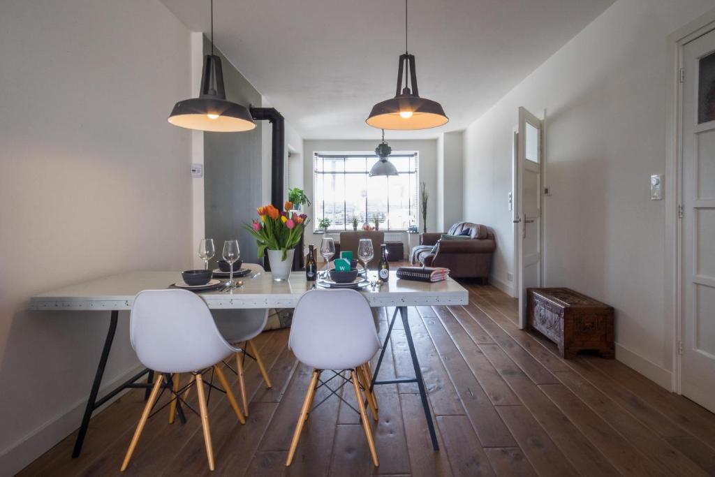 cocina y sala de estar con mesa y sillas en Wijkiki Surf House, en Wijk aan Zee