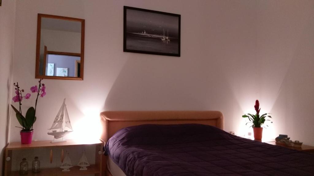 sypialnia z łóżkiem i lustrem na ścianie w obiekcie Terra Rossa w mieście Loborika