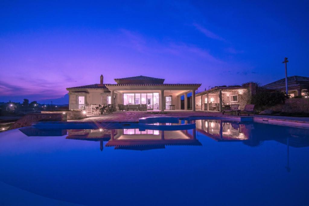 a house with a swimming pool at night at Villa Diamond in Porto Heli