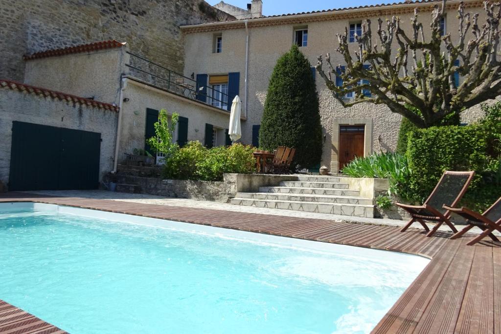 a swimming pool in front of a house at Maison de Vacances La Commanderie in Mormoiron