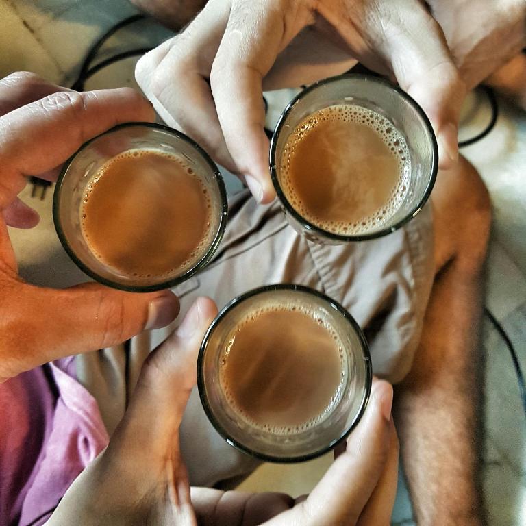 a group of people holding up cups of coffee at JHouse near Bhikaji in New Delhi