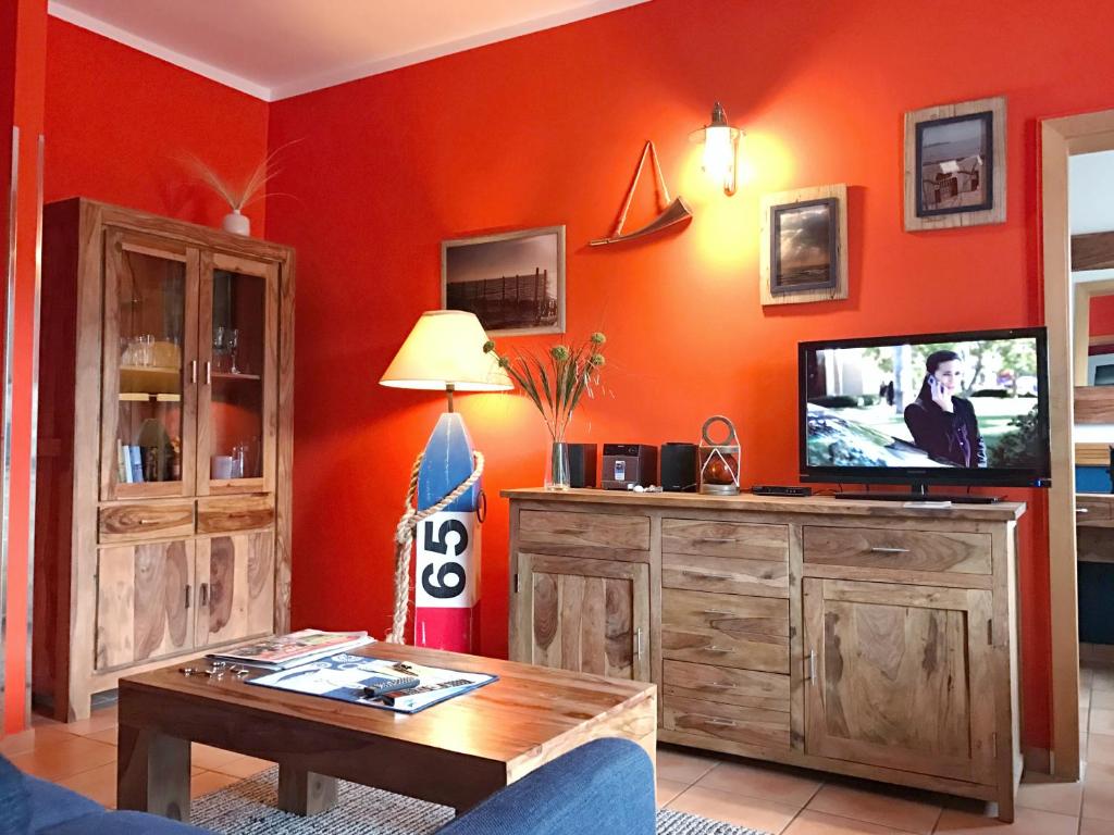 a living room with a flat screen tv on a wooden cabinet at Villa Daheim - Kajüte 12 in Juliusruh