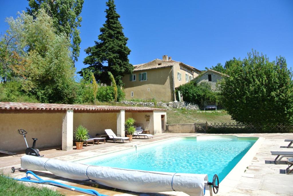 a swimming pool in front of a house at Maison d'Hôtes La Honas in La Rochette-du-Buis