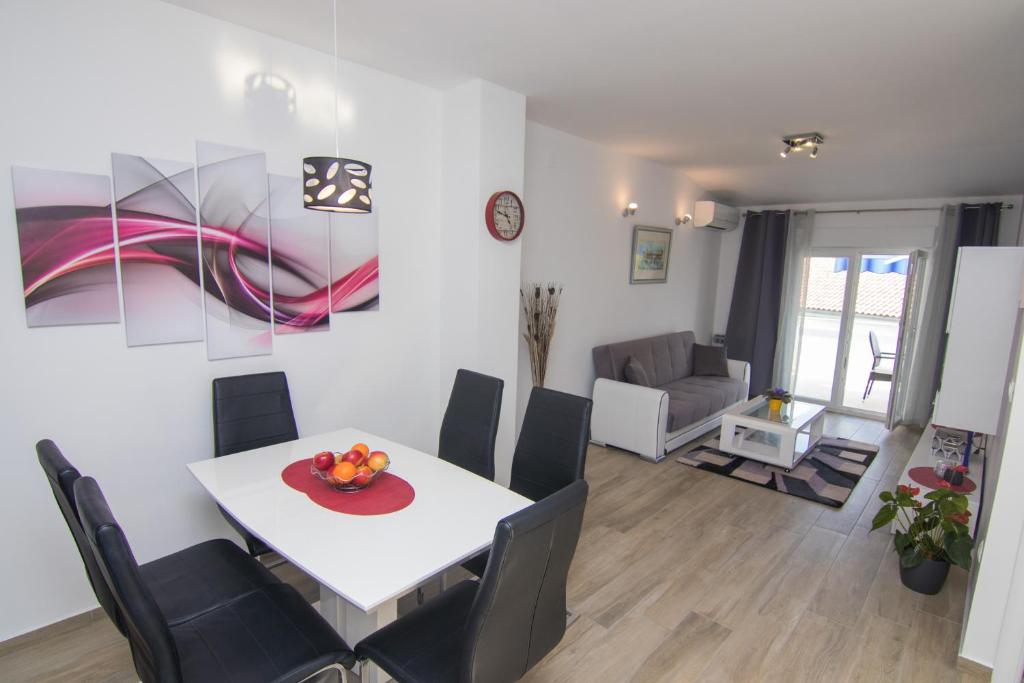 een eetkamer en een woonkamer met een tafel en stoelen bij Apartment Neda in Krk