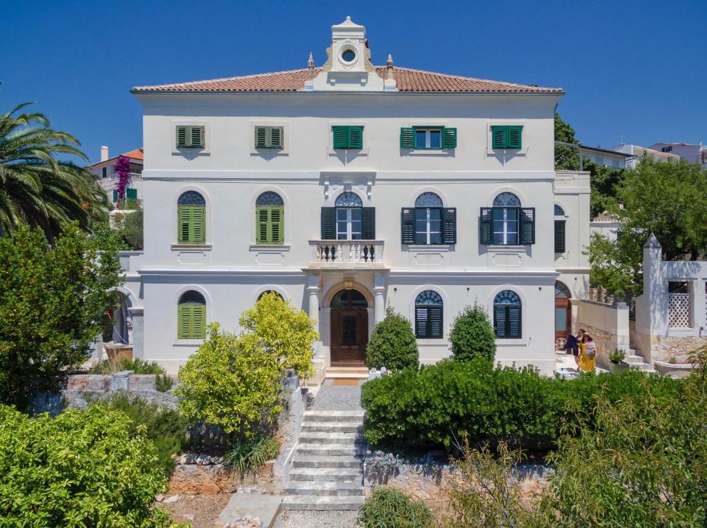 ein großes weißes Haus mit einem Uhrturm in der Unterkunft Villa Marchi in Hvar