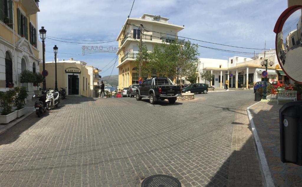 a street in a town with a truck parked on the street at Platanos Rooms in Agia Marina