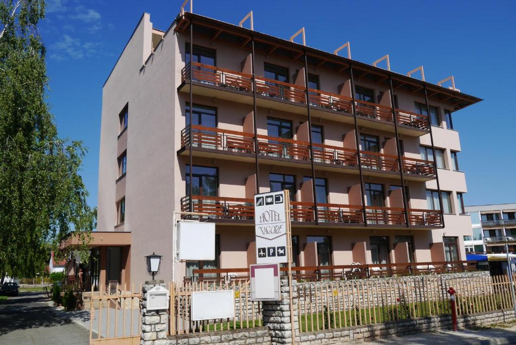 un immeuble d'appartements avec un panneau en face de celui-ci dans l'établissement Hotel Tagore, à Balatonfüred