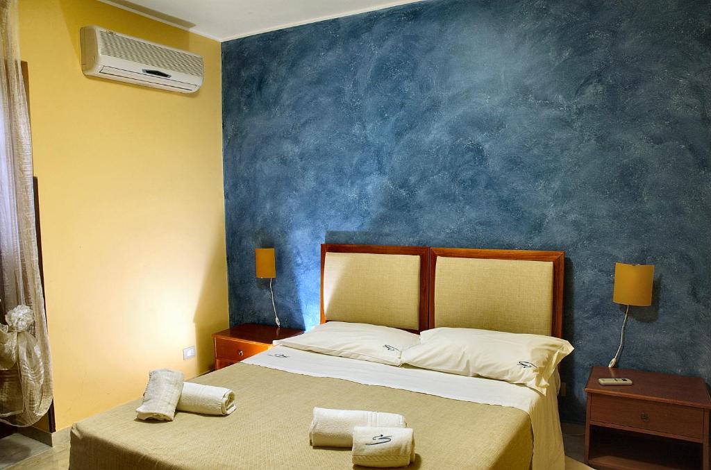 チェファルにあるMiraMare Residence Cefalúの青い壁のベッドルーム1室(ベッド1台付)