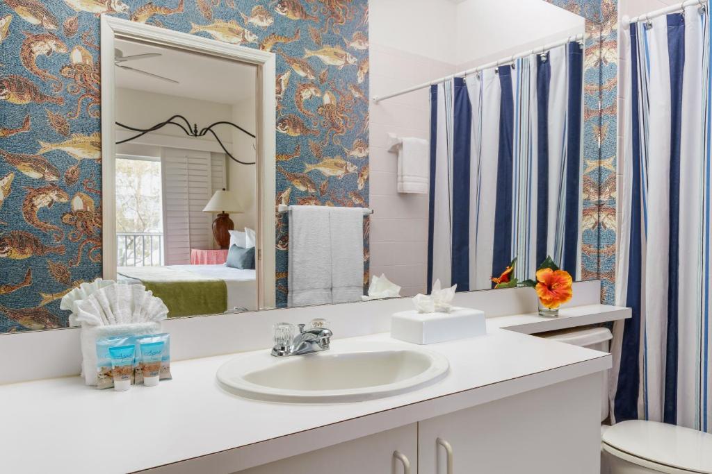 a bathroom with a sink and a mirror at Olde Marco Island Inn and Suites in Marco Island