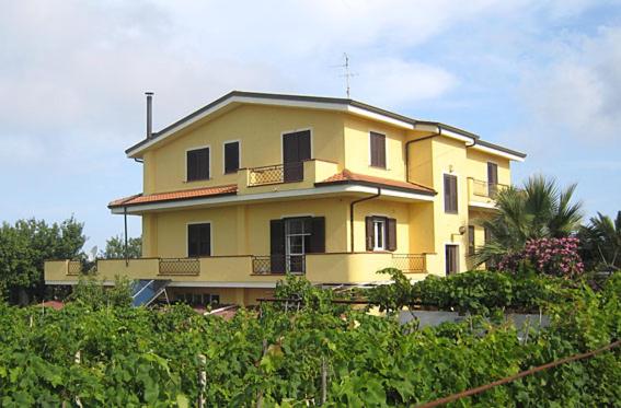 ein gelbes Haus mit Balkon darüber in der Unterkunft B&B Meligrana in Capo Vaticano