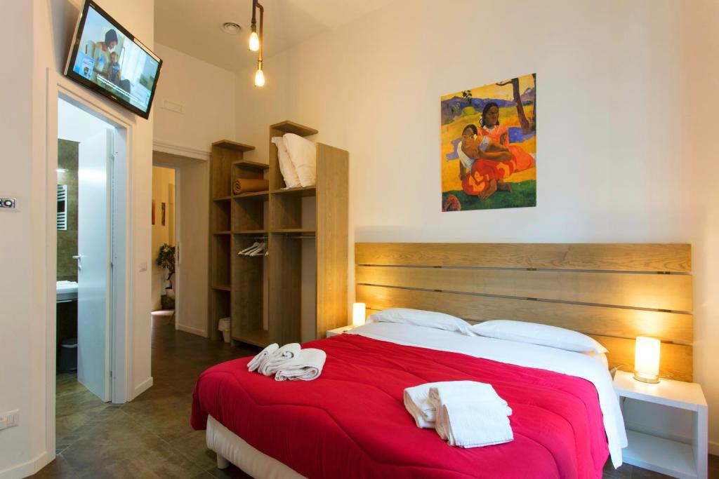 ナポリにあるB&B A Durmìのベッドルーム1室(赤いベッド1台、タオル付)