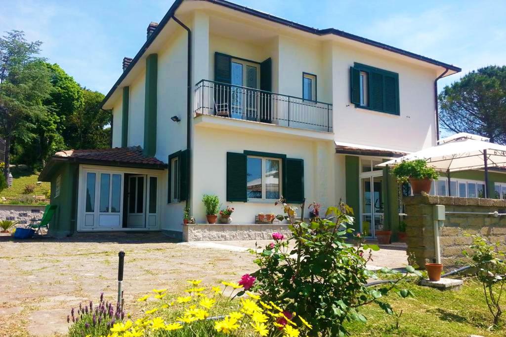 a large house with green shutters and a yard at Bed and Breakfast Romantica Evasione in Sutri
