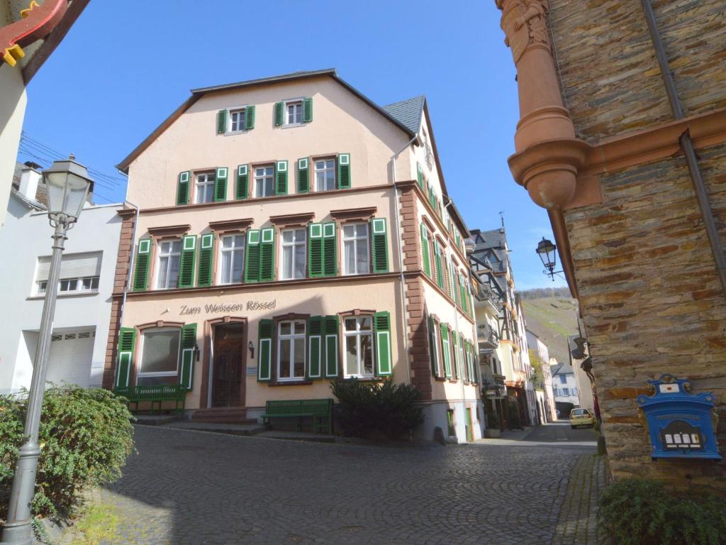 a building with green shutters on a street at Beautiful holiday home with private pool 5 km away from Lim Fjord in Ürzig