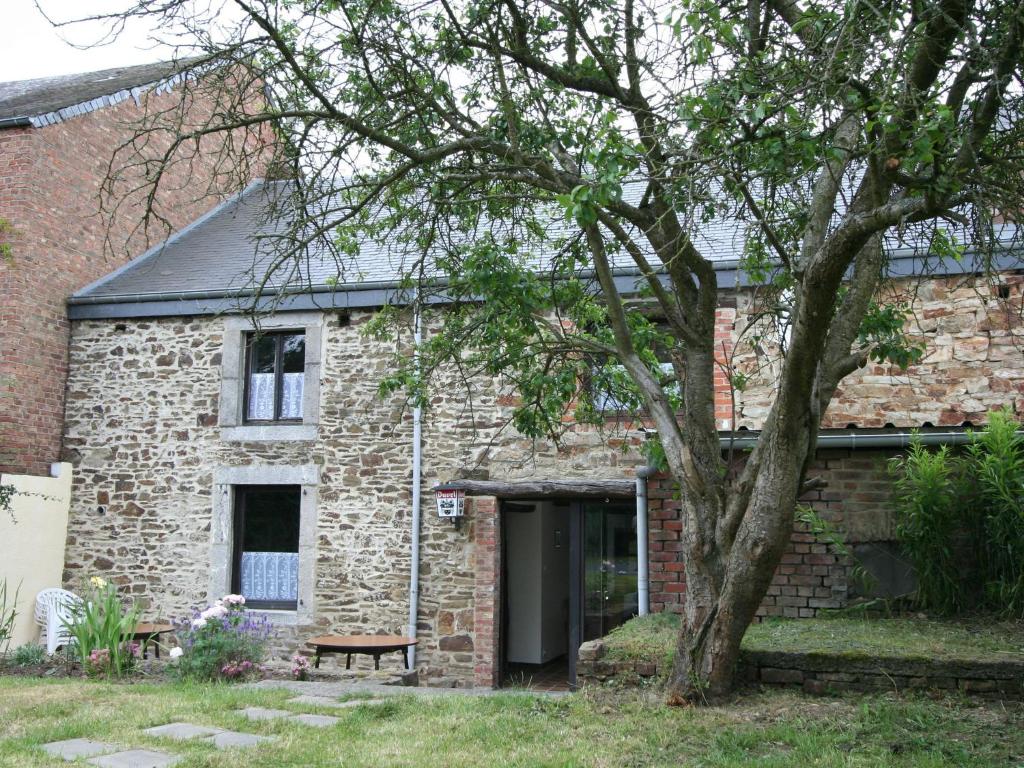 ein Backsteinhaus mit einem Baum davor in der Unterkunft Charming Country Cottage in Winenne with Garden in Beauraing