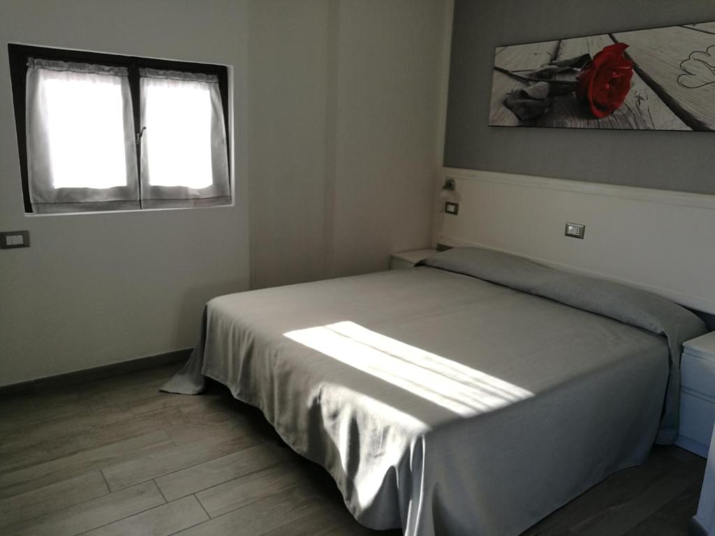 1 dormitorio con 1 cama y 2 ventanas en IRON GATE MARINA3B, en Sarzana