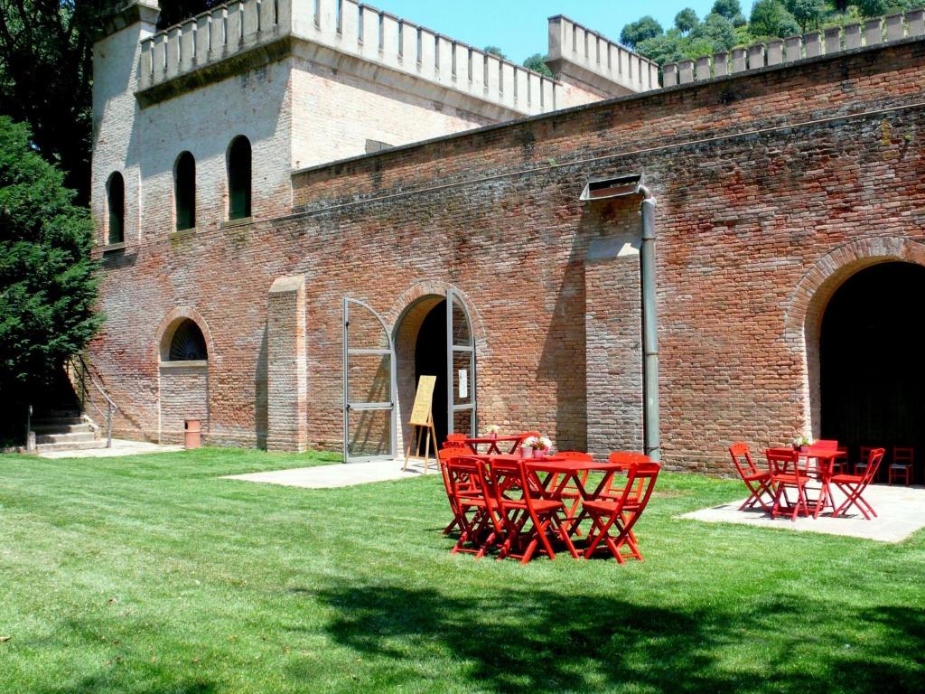 モンセーリチェにあるRegal Castle near Padua and Venice with scenic beautyのレンガ造りの建物前の赤いテーブル