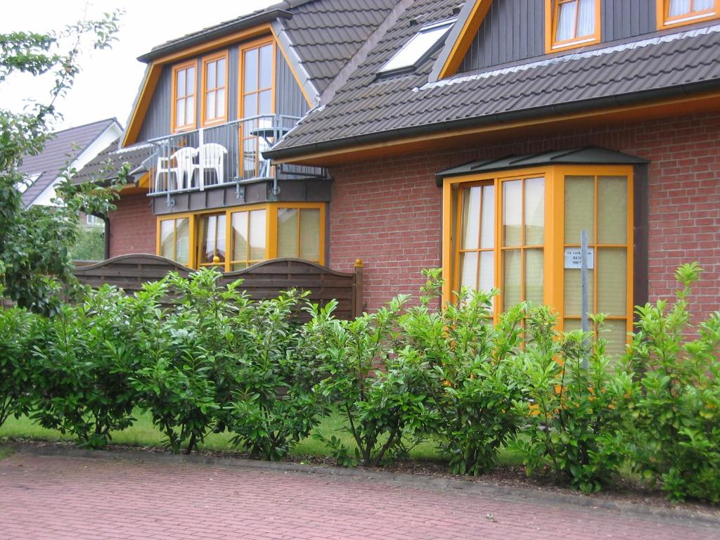 シェーンベルガー・シュトランドにあるFerienwohnung Sonnenscheinの黒い屋根の赤いレンガの家